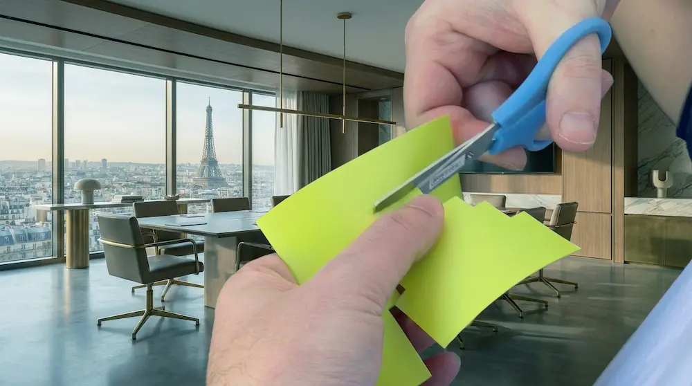 Gros plan sur la découpe de vinyle jaune avec des ciseaux bleus, dans un bureau de direction avec vue sur la Tour Eiffel